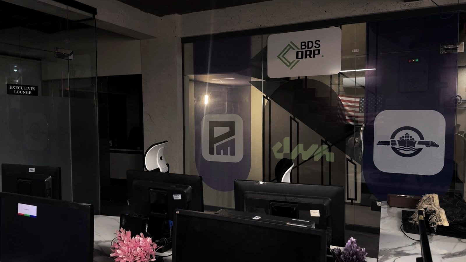 Glass partition carrying the BDS Corp, Publisive Media, DNA PR and Badass Logistics marks, beside the executives lounge