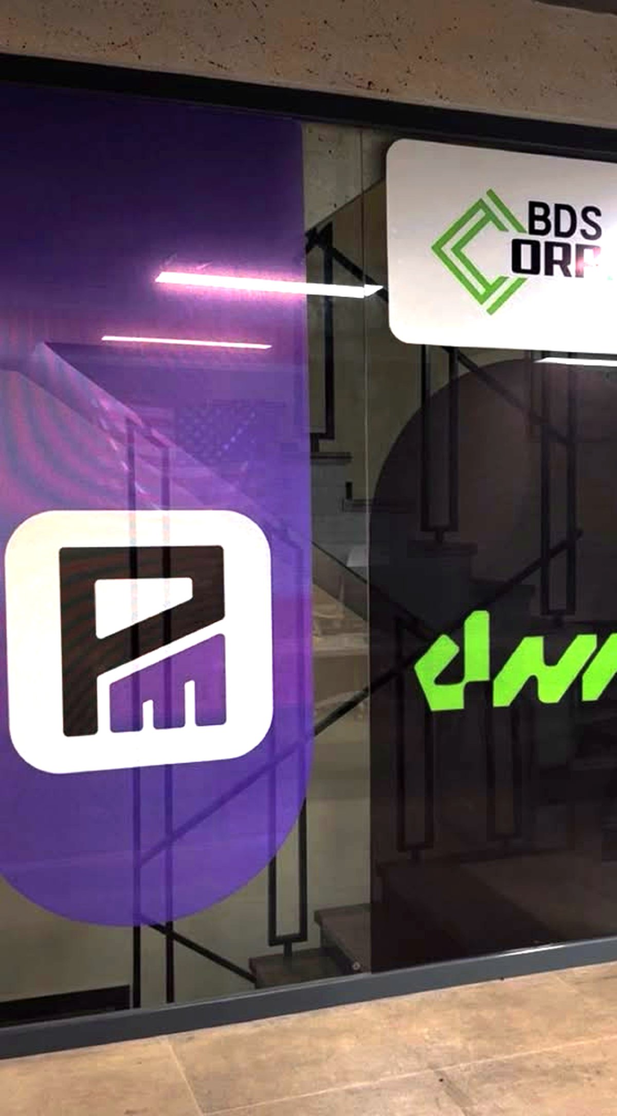 The Publisive Media mark on the glass wall of the BDS Corp head office, beside the BDS Corp and DNA marks