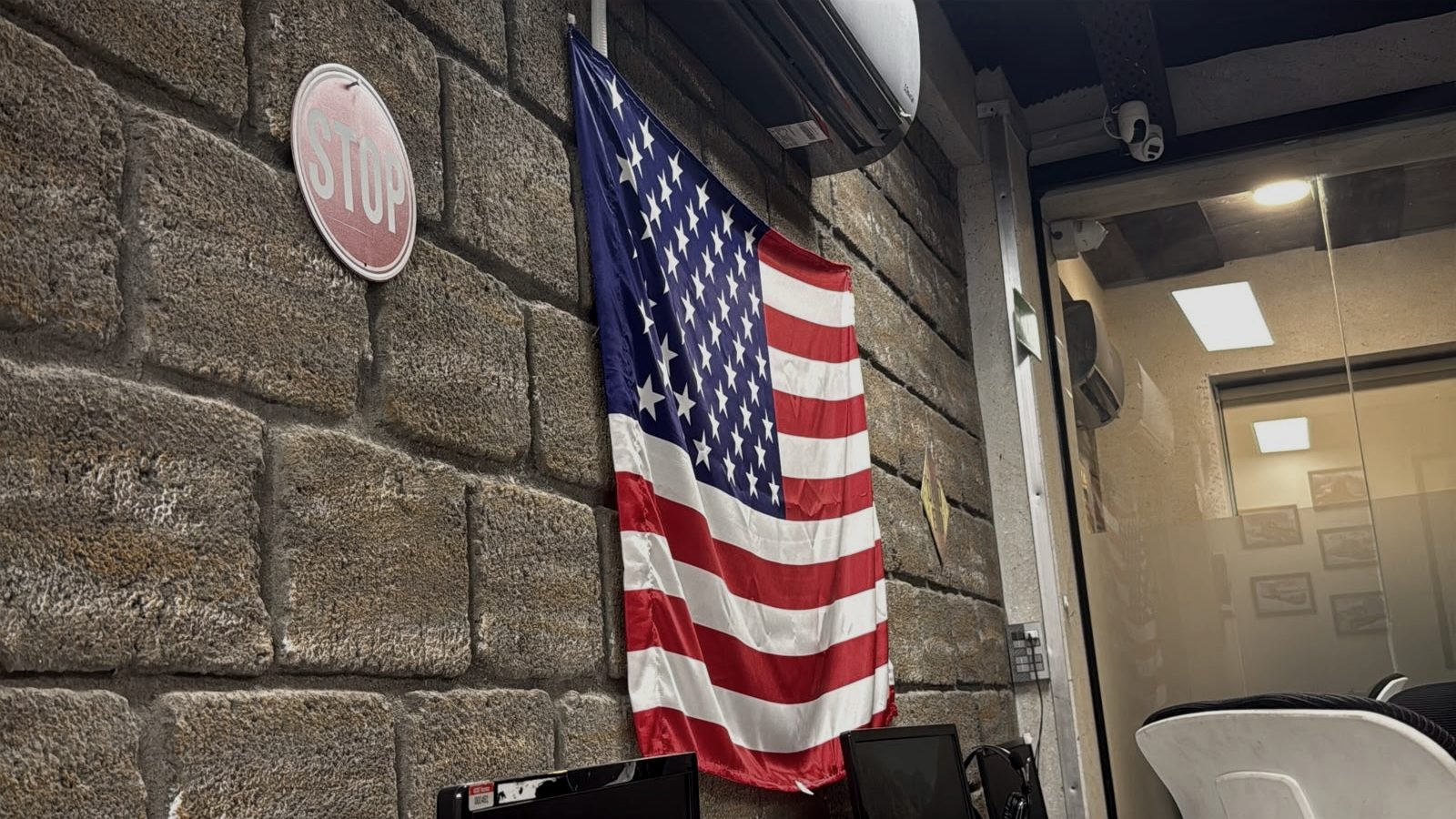 A United States flag and a highway stop sign mounted on the stone wall of the operations floor